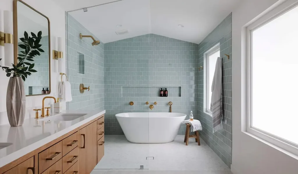 A minimalist spa-like bathroom with blue subway tiles and a freestanding bathtub- A top bathroom trend