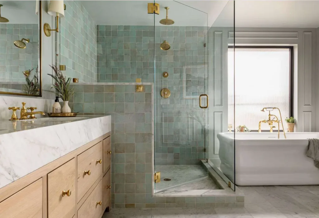 Modern bathroom with half-wall glass shower, marble countertop & freestanding bathtub